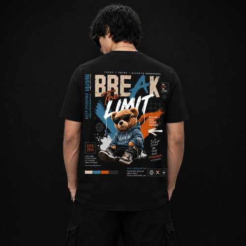 A man viewed from behind wearing a black short-sleeve t-shirt with a large graphic print on the back. The graphic features the text 'BREAK THE LIMIT' in white and orange, a cartoon teddy bear in a denim jacket and sunglasses, and blue and orange paint splatter details, set against a dark studio background.