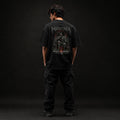 Person wearing a black t-shirt with 'Mavora' branding on the back against a dark background