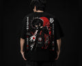 Person wearing a black t-shirt with a graphic design on the back against a dark background