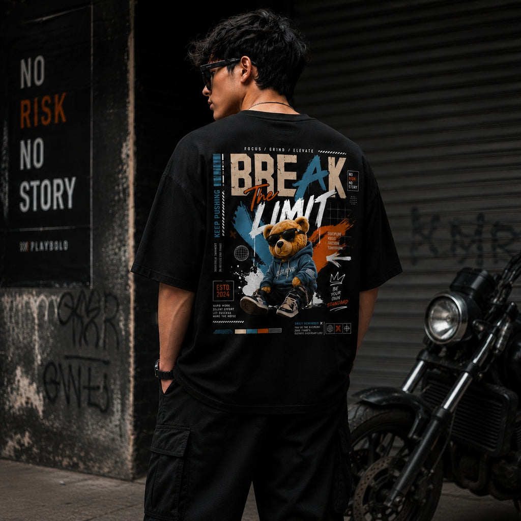 Person wearing a black t-shirt with a graphic design, standing next to a motorcycle in an urban setting.