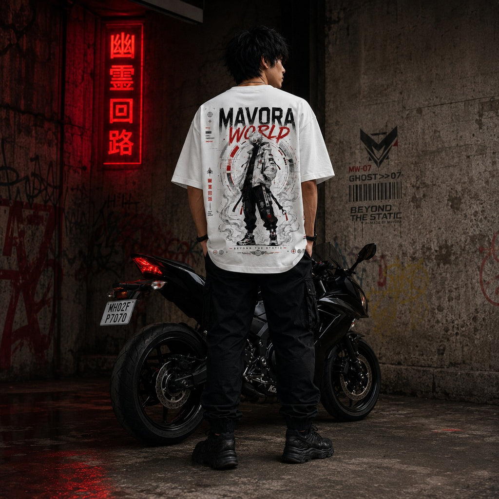 Person wearing a white t-shirt with 'MAVORA WORLD' design standing next to a motorcycle in an urban setting.