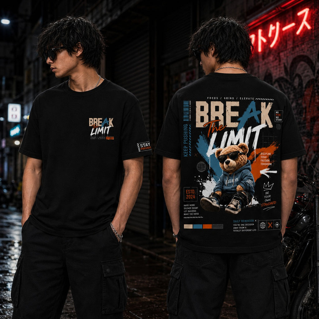 Two models wearing a black graphic t-shirt in a dark urban street setting at night. The front view shows a small 'BREAK THE LIMIT' graphic on the chest, while the back view reveals a large, detailed graphic featuring a cartoon bear in a blue hoodie and the text 'BREAK THE LIMIT' in white, orange, and blue.